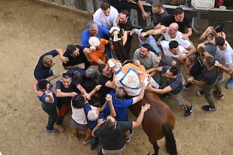 Jockey Giovanni Atzeni, called Tittia, who mounted   Violenta da codia  , wins the historical Italian horse race Palio di Siena, in Siena, Italy, 17 August 2022
ANSA/CLAUDIO GIOVANNINI