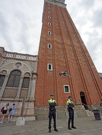 Due agenti della Municipale presidiano l’uscita dal campanile di San Marco, da dove si son staccati frammenti dei mattoni della torre a causa del nubifragio che oggi, 18 agosto 2022, si è abbattuto sulla città. ANSA/ANDREA MEROLA                               