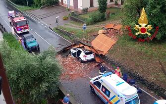 I vigili del fuoco intervengono per rimuovere un tetto volato via da una abitazione che ha  centrato un auto a Fornaci di Barga (Lucca), 18 agosto 2022.
ANSA/VIGILI DEL FUOCOEDITORIAL USE ONLY NO SALES