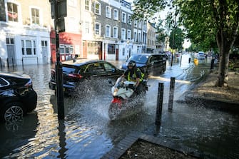 LONDON, ENGLAND - AUGUST 08: A motorcyclist negotiates th substantial flooding on roads near to the Arsenal Stadium, following a rupture of water mains, on August 08, 2022 in London, United Kingdom. Cars were semi-submerged with houses and business suffering flooding. (Photo by Leon Neal/Getty Images)