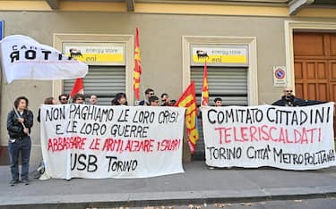Representatives of the Usb (basic union union)hold a banner where is seen: "We do not pay for their crises and their wars. Lower weapons and raise wages" under the building of the Eni energumeni store to protest against the expensive bills and denounce the speculations of multinationals in Turin, Italy, 03 October 2022. 
ANSA/ALESSANDRO DI MARCO