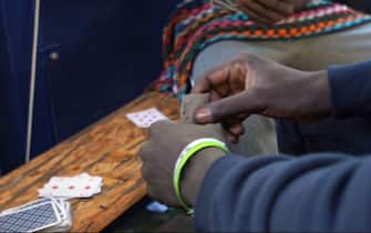 un migrante gioca a carte