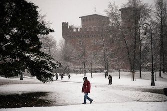 A man walks near the Valentino Castle as snow falls in Turin, on December 8, 2021. (Photo by MARCO BERTORELLO / AFP) (Photo by MARCO BERTORELLO/AFP via Getty Images)