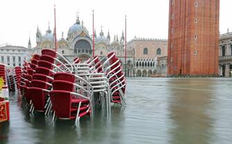 Red submerged chairs in Saint Mark Square full of water in Venice Italy  during the flood