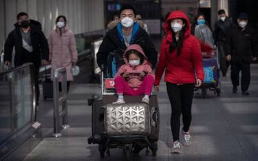 BEIJING, CHINA - JANUARY 30: Passengers wear protective masks as they walk he their luggagein the arrivals area at Beijing Capital Airport on January 30, 2020 in Beijing, China. The number of cases of a deadly new coronavirus rose to over 7000 in mainland China Thursday as the country continued to lock down the city of Wuhan in an effort to contain the spread of the pneumonia-like disease which medicals experts have confirmed can be passed from human to human. In an unprecedented move, Chinese authorities put travel restrictions on the city which is the epicentre of the virus and neighbouring municipalities affecting tens of millions of people. The number of those who have died from the virus in China climbed to over 170 on Thursday, mostly in Hubei province, and cases have been reported in other countries including the United States, Canada, Australia, Japan, South Korea, and France. The World Health Organization  has warned all governments to be on alert, and its emergency committee is to meet later on Thursday to decide whether to declare a global health emergency. (Photo by Kevin Frayer/Getty Images)