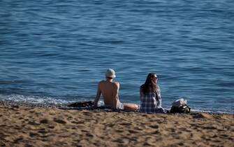 BARCELONA, CATALONIA, SPAIN - 2022/12/25: A couple enjoys Christmas day on the seashore at Playa de la Barceloneta. Unusual temperatures in Catalonia (Spain) that is forecast as Christmas Day with the warmest temperature of the century with highs of 23 and 24 º. (Photo by Paco Freire/SOPA Images/LightRocket via Getty Images)