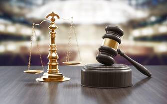 Un martelletto da giudice Judges Gavel And Scale Of Justice On The Black Wood Background, Top View. Law Concept. 3d rendering