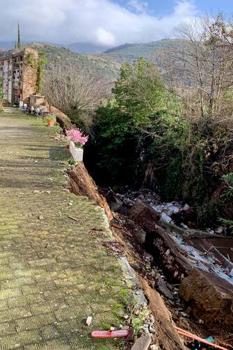 Una ventina di bare e 80 urne sono finite in un torrente in seguito al cedimento di un'ala del cimitero. È accaduto a S. Agata dei Goti, in provincia di Benevento, 19 gennaio 2023. 
ANSA