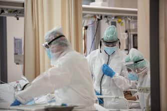 Operatori sanitari, che indossano tute protettive mediche e mascherine, al lavoro nella  terapia intensiva dell'Ospedale Sant'Orsola di Bologna, 12 novembre 2020. Ansa/Max Cavallari