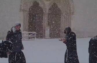 Frati francescani giocano a palle di neve fuori dalla Basilica di San Francesco