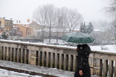 A person walks in the centre of Rieti with an umbrella under the snow, during the snowfall of 23 January 2023.  (Photo by Riccardo Fabi/NurPhoto via Getty Images)