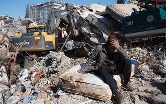 A man sits on ruins in Kahramanmaras, Turkey, Wednesday, February 8, 2023. On February 6, a 7.8-magnitude shook Turkey and Syria, followed a few hours later by 7.5-magnitude earthquake. The death toll rises to 11600 in Turkey and Syria. (Photo by Arnaud Andrieu/Sipa Press).