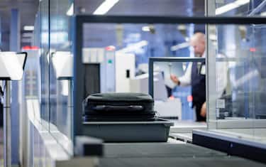 22 June 2022, Hamburg: A piece of hand luggage is passed through a scanner by a member of the security staff at Hamburg airport.      (to dpa "Busy at the airport - this is how the security check works") Photo: Axel Heimken/dpa (Photo by Axel Heimken/picture alliance via Getty Images)