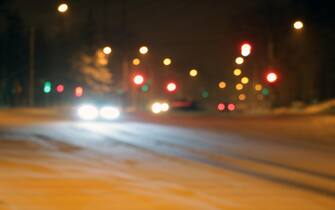 Cars on the winter road with snow. Dangerous car traffic in bad weather with bokeh at night to use background