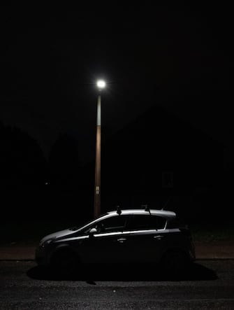 Car parked after darkness under a street lamp