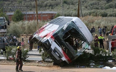 epa05222674 Firemen work at the site of a coach crash that has left at least 14 students dead at the AP-7 motorway in Freginals, in the province of Tarragona, northeastern Spain, 20 March 2016. The coach carrying dozens of Erasmus students collided with a car and overturned. The students from several different countries were heading to Barcelona after attending Las Fallas Festival in Valencia, eastern Spain.  EPA/JAUME SELLART