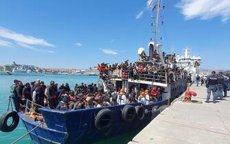 The fishing boat carrying about 600 migrants rescued in recent days 100 miles off the coast of Sicily towed by a tugboat arrived in the port of Catania, Italy, 12 April 2023. The vessel was escorted by the 'Nave Peluso' of the Coast Guard. The migrants on board greeted their arrival with applause and whistles and shouts of 'Bella Italia'.ANSA/Orietta Scardino