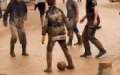Alluvione Emilia Romagna, ragazzi giocano a calcio nel fango