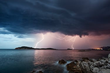 A violent thunderstorm approaching over the Adriatic Sea, with the lights of Dubrovnik Old Town visible in the distance, Dalmatia, Croatia.