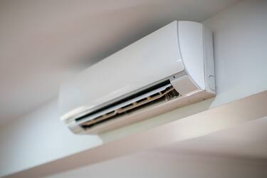 Close up of an air conditioner on a white wall
