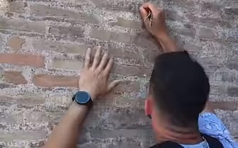 Frame del video pubblicato su Reddit in cui si vede un turista - ancora non identificato - imbrattare il Colosseo incidendo con delle chiavi il nome suo e della fidanzata (Ivan+Haley 23), Roma, 26 giugno 2023. 
REDDIT/RYTZ5873

(monumenti, vandalizzati)