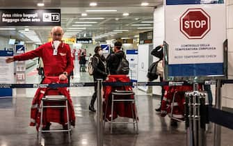 An airport staff directs passengers exiting an airplane that landed at Rome's Fiumicino airport from Paris on March 7, 2020 as part of body temperature screening procedures to prevent the spread of the new coronavirus. - Italy prepared on March 7, 2020 to quarantine more than 10 million people around the financial capital Milan and the tourist mecca Venice for nearly a month to halt the spread of the new coronavirus. A draft government decree published by Italy's Corriere Della Sera newspaper and other media said movement into and out of the regions would be severely restricted until April 3. (Photo by Laurent EMMANUEL / AFP) (Photo by LAURENT EMMANUEL/AFP via Getty Images)