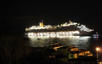 A photograph taken early on January 14, 2012 of the Costa Concordia after the cruise ship with more than 4,000 people on board ran aground and keeled over off the Isola del Giglio, and Italian island, last night. Three people died and several were missing Saturday after a cruise ship with more than 4,000 people on board ran aground and keeled over off an Italian island, sparking chaos as passengers scrambled to get off. The ship was on a cruise in the Mediterranean, leaving from Savona with planned stops in Civitavecchia, Palermo, Cagliari, Palma, Barcelona and Marseille," the company said. AFP PHOTO / LUCA MILANO (Photo credit should read Luca Milano/AFP via Getty Images)