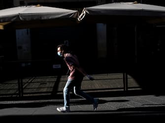 Florence, Italy May 7th 2020. A passerby run on the street of the city centre, during the last days of the phase one of Coronavirus lockdown. The virus epidemic spread in Italy in March 2020.