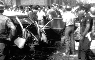 Inquirenti davanti all'auto blindata del giudice Rocco Chinnici morto nell'attentato  avvenuto a Palermo il 29 luglio 1983 ANSA 
