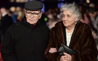 Italian composer Ennio Morricone poses with his wife Maria Travia on the red carpet of the European premiere of film 'The Hateful Eight' in London on December 10, 2015.  AFP PHOTO / LEON NEAL (Photo by LEON NEAL / AFP)        (Photo credit should read LEON NEAL/AFP via Getty Images)