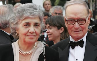Cannes, FRANCE: Italian composer Ennio Morricone (R) and his wife Maria Travia pose 25 May 2007 upon arriving at the Festival Palace in Cannes, southern France, for the premiere of US director James Gray's film 'We Own the Night' during the 60th edition of the Cannes Film Festival. The film is in competition for the Palme d'Or prize. The Cannes festival unspooled some of its last films Friday as it prepared for its weekend climax -- an awards night that will reward one of 22 competition films with the prestigious Palme d'Or.         AFP PHOTO / FRANCOIS GUILLOT (Photo credit should read FRANCOIS GUILLOT/AFP via Getty Images)