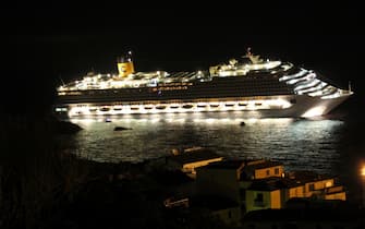 The Costa Concordia is pictured on January 14, 2012, after the cruise ship ran aground and keeled over off the Isola del Giglio, last night.  Three people died and about 70 were missing after an Italian cruise ship with more than 4,000 people on board ran aground and keeled over, sparking scenes of panic.  The Costa Concordia was on a trip around the Mediterranean when it apparently hit a reef near the island of Giglio on Friday, only a few hours into its voyage, as passengers were sitting down for dinner. AFP PHOTO / Giorgio Fanciulli / Giglionews (Photo credit should read Giorgio Fanciulli/Giglionews/AFP via Getty Images)