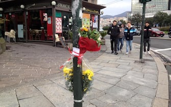 Un biglietto e un mazzo di fiori sul luogo dell'omicidio di un uomo marocchino ucciso a sprangate, Genova, 2 febbraio 2013. ANSA/ LUCA ZENNARO
