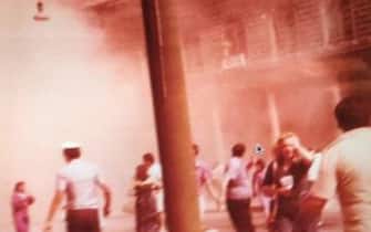 Strage Di Bologna Una foto che ritrae il piazzale della stazione di Bologna la mattina del 2 agosto 1980, poco dopo l'esplosione che causÚ 85 morti e 200 feriti. L'immagine inedita, a colori, Ë stata ritrovata dall'avvocato Andrea Speranzoni, difensore dell'associazione dei familiari delle vittime della Strage. Si vedono tra l'altro una donna che sembra allontanarsi andando incontro all'obiettivo, con una borsa sulla spalla destra e l'altra mano sulla tempia, un vigile urbano di spalle e altre persone in secondo piano, mentre sullo sfondo il fumo ha invaso l'ingresso della stazione e si Ë propagato all'esterno, fino ad arrivare pi˘ in alto del tetto.
ANSA