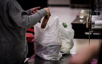 In this picture taken on November 7, 2018, a woman packs her shopping into a plastic bag in a supermarket in Chiba. - From bento boxes to individually wrapped bananas, plastic reigns supreme in Japan. But amid global concern about single-use waste, new legislation could help end the country's love affair with plastic. (Photo by Martin BUREAU / AFP) / To go with AFP story Japan-environment-pollution-waste-synthetics,FOCUS by Sara Husssein        (Photo credit should read MARTIN BUREAU/AFP via Getty Images)
