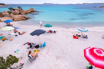 PORTO CERVO, ITALY - JUNE 07: Some tourists on a beach in Sardinia try to respect the rules of social distancing by using a white and red ribbon to mark their space on the beach on the first weekend of phase 3 after the lockdown due to Covid-19 on June 07, 2020 in Porto Cervo, Sardegna, Italy. Many Italian businesses have been allowed to reopen, after more than two months of a nationwide lockdown meant to curb the spread of Covid-19. (Photo by Emanuele Perrone/Getty Images)
