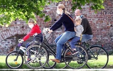Una famiglia  in bicicletta al parco Sempione di Milano  nel primo giorno della "Fase2" determinata dall'emergenza del Coronavirus. Milano 4 Maggio 2020.
ANSA / MATTEO BAZZI
