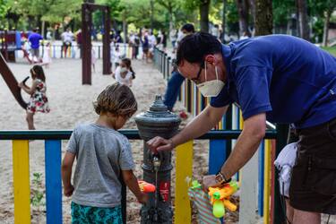 MADRID, SPAIN - JUNE 23: A man fills a toy water gun for a kid in a children's park on June 23, 2020 in Madrid, Spain. From today Children's playgrounds reopen in Madrid after almost one hundred days closed because of the coronavirus crisis. (Photo by Ely Pineiro/Getty Images)