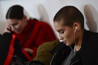 Models listen to music backstage prior to the women's Fall/Winter 2018/2019 collection fashion show by Mila Schon, in Milan, on February 24, 2018. / AFP PHOTO / Miguel MEDINA        (Photo credit should read MIGUEL MEDINA/AFP via Getty Images)