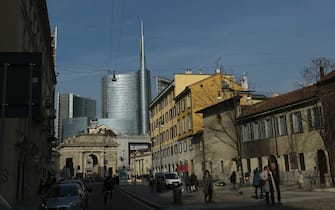 A picture shows the Unicredit tower behind the "Porta Nuova" monument (L) on February 27, 2015 in Milan. Qatar's sovereign fund has acquired full control of a piece of prime real estate in Milan after buying out other shareholders, property group Hines Italia announced on February 27, 2015. Qatar has owned 40 percent of the Porta Nuova business district since 2013. Hines and insurer Unipol were among the selling shareholders in a 25-building development conservatively valued at more than two billion euros.   AFP PHOTO / FILIPPO MONTEFORTE        (Photo credit should read FILIPPO MONTEFORTE/AFP via Getty Images)