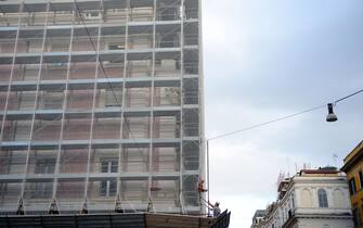 Workers are pictured on scaffoldings during the restoration of a building on November 20, 2014 in Rome.  AFP PHOTO / GABRIEL BOUYS        (Photo credit should read GABRIEL BOUYS/AFP via Getty Images)