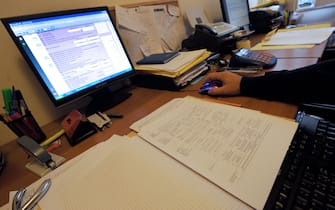 An accountant checks tax forms of one of his clients in his office in Naples on October 22, 2012.  AFP PHOTO / MARIO LAPORTA        (Photo credit should read MARIO LAPORTA/AFP via Getty Images)