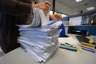 An employee goes through documents in a tax office on November 7, 2012 in Rome.  AFP PHOTO / ANDREAS SOLARO        (Photo credit should read ANDREAS SOLARO,ANDREAS SOLARO/AFP via Getty Images)