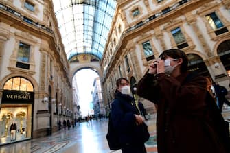 Tourists wearing protective masks take pictures in Galleria Vittorio Emanuele II in the centre of Milan, on February 28, 2020, after COVID-19, the novel coronavirus, spread to Italy. - Italy urged tourists spooked by the new coronavirus on February 28 not to stay away, but efforts to reassure the world it was managing the outbreak were overshadowed by a sharp rise in case numbers. Some 650 people have tested positive for the virus in Italy, though only 303 are considered serious clinical cases, and deaths hit 17 -- by far the highest in Europe -- according to the latest figures from the civil protection agency. (Photo by Miguel MEDINA / AFP) (Photo by MIGUEL MEDINA/AFP via Getty Images)