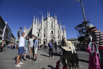 Tourists take pictures in front of the Duomo Cathedral, the largest church in Italy, in central Milan on May 30, 2019. (Photo by Miguel MEDINA / AFP)        (Photo credit should read MIGUEL MEDINA/AFP via Getty Images)