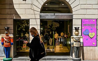 A woman walks past a kid's luxury fashion clothing shop, on which a placard reads "Close Out Sale, up 70 percent discount" on May 21, 2020 in Rome as the country eases its lockdown aimed at curbing the spread of the COVID-19 infection, caused by the novel coronavirus. - Many Italian shopkeepers, most of them restaurant owners, prefer not to reopen their business despite calls from the government to do so. (Photo by Vincenzo PINTO / AFP) (Photo by VINCENZO PINTO/AFP via Getty Images)