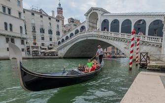 VENICE, ITALY - JULY 22: Gondolier takes tourists near the Rialto Bridge on July 22, 2020 in Venice, Italy. A new rule in Venice will make becoming a gondolier more difficult by asking to prove that you have been working for the last four years on a family Gondola. (Photo by Stefano Mazzola/Awakening/Getty Images)