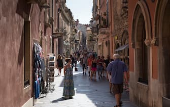 1140991720 TAORMINA, ITALY: Tourists in street scene in the city of Taormina, East Sicily, Italy.