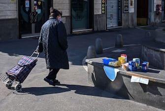 Una donna passeggia con una borsa per la spesa in una strada cittadina