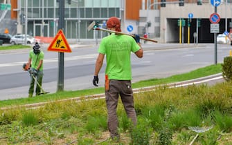 Giardinieri muniti di mascherina protettiva sistemano le aree verdi in zona Porta Nuova , Milano, 28 Aprile 2020.
ANSA/Andrea Fasani